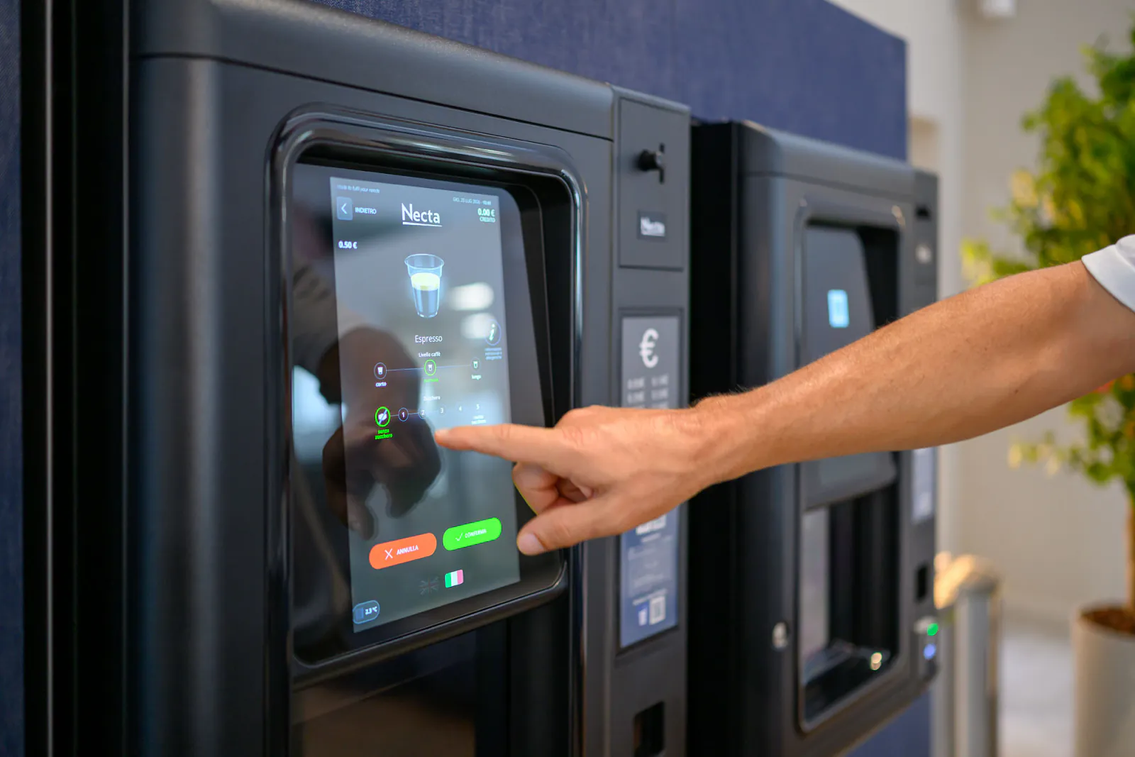 Una persona utilizza il distributore, con le altre macchine dell’installazione visibili accanto.