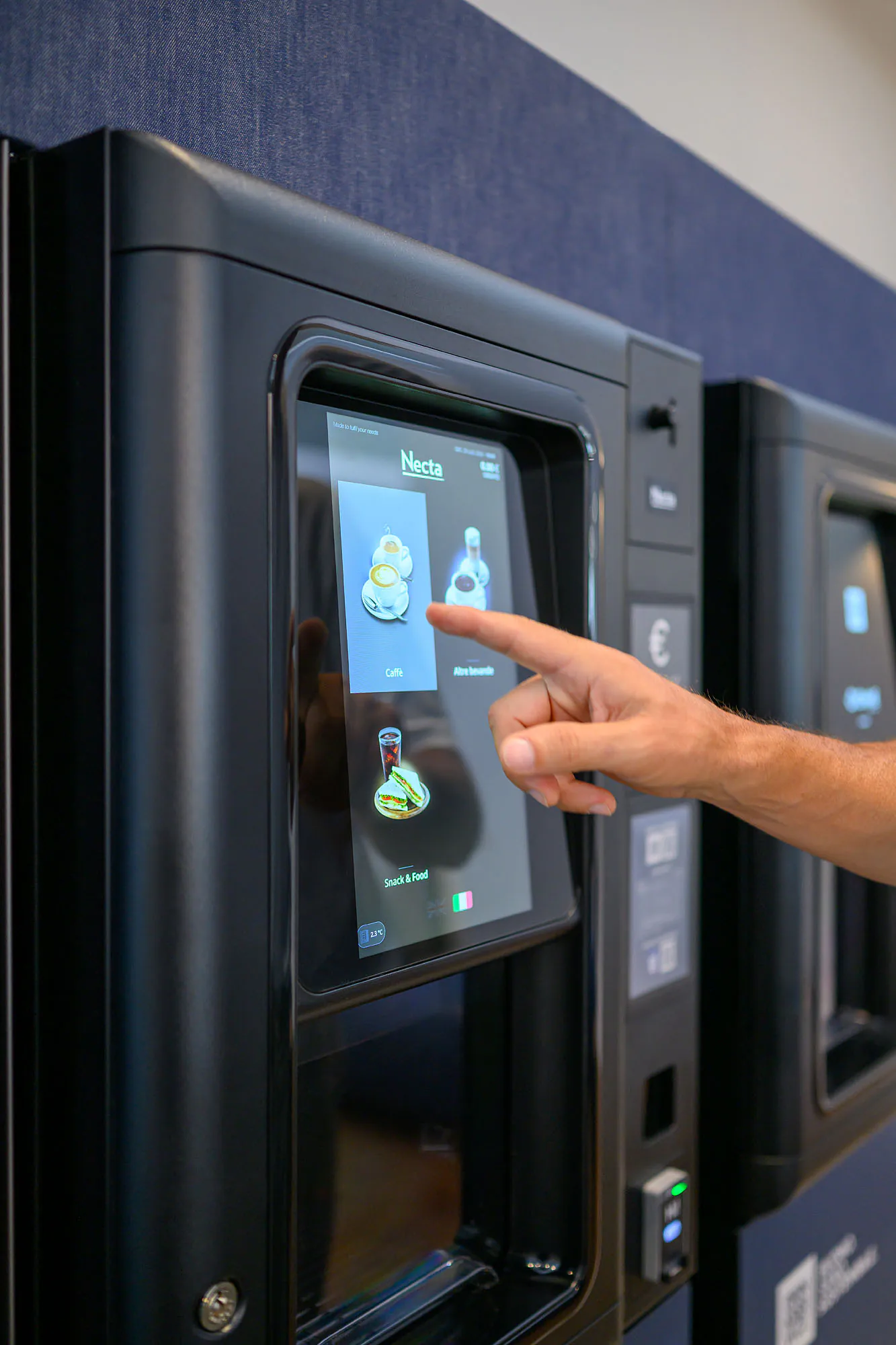 Una persona utilizza il distributore, con le altre macchine dell’installazione visibili accanto.
