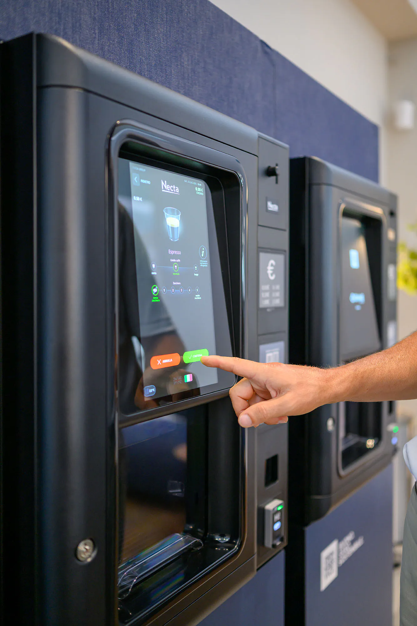 Una persona utilizza il distributore, con le altre macchine dell’installazione visibili accanto.