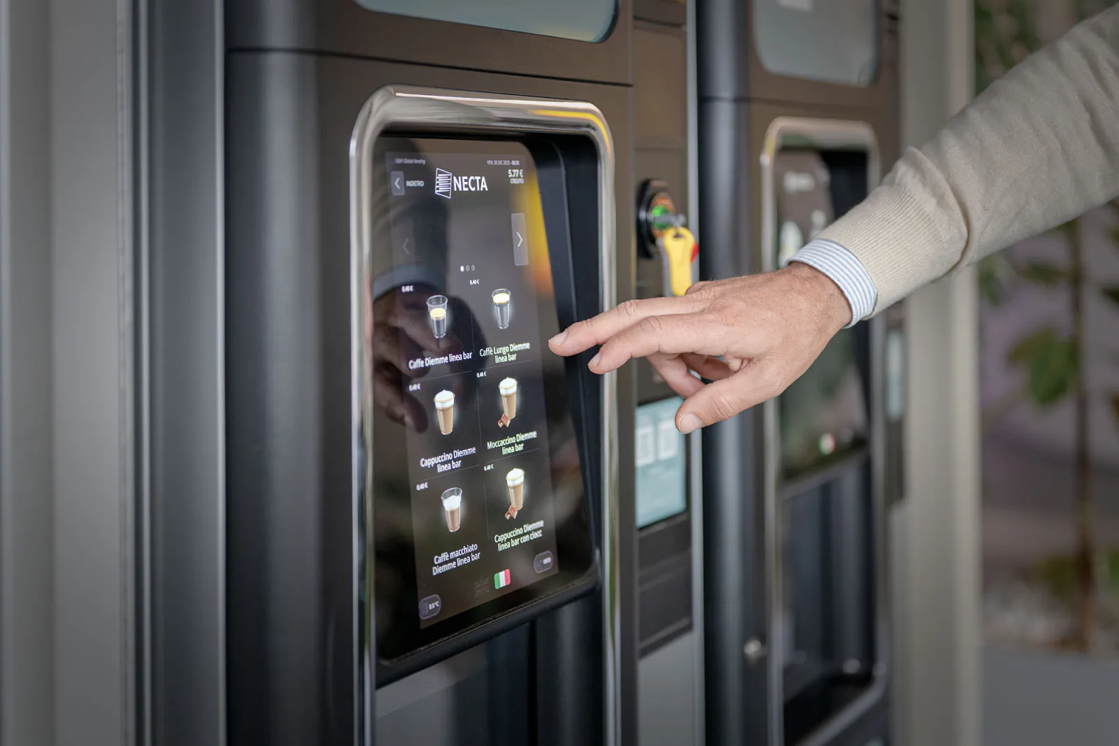 Una persona utilizza il distributore, con le altre macchine dell’installazione visibili accanto.