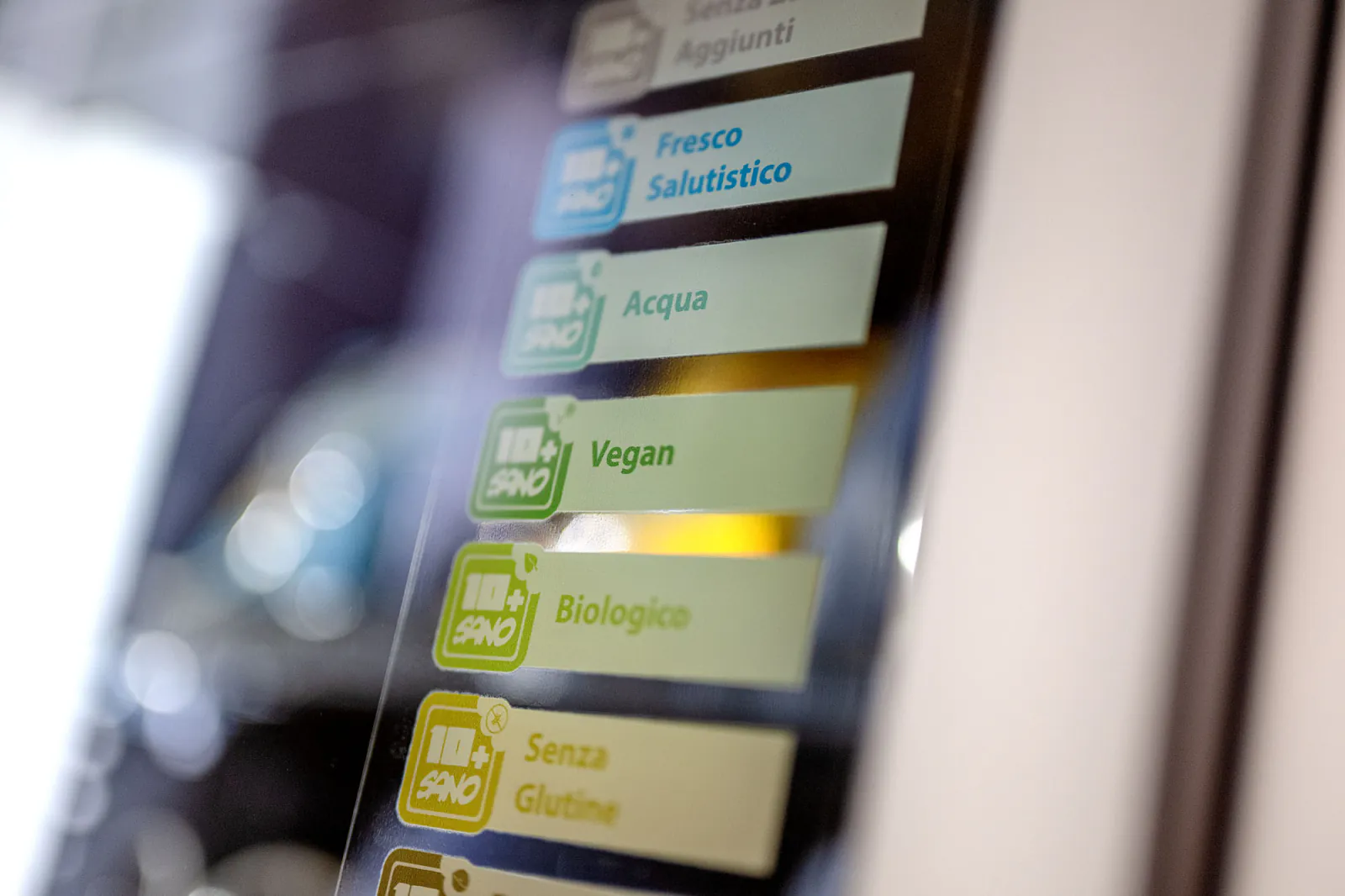 Dettaglio delle etichette per prodotti freschi, biologici, vegani e senza glutine su un distributore.